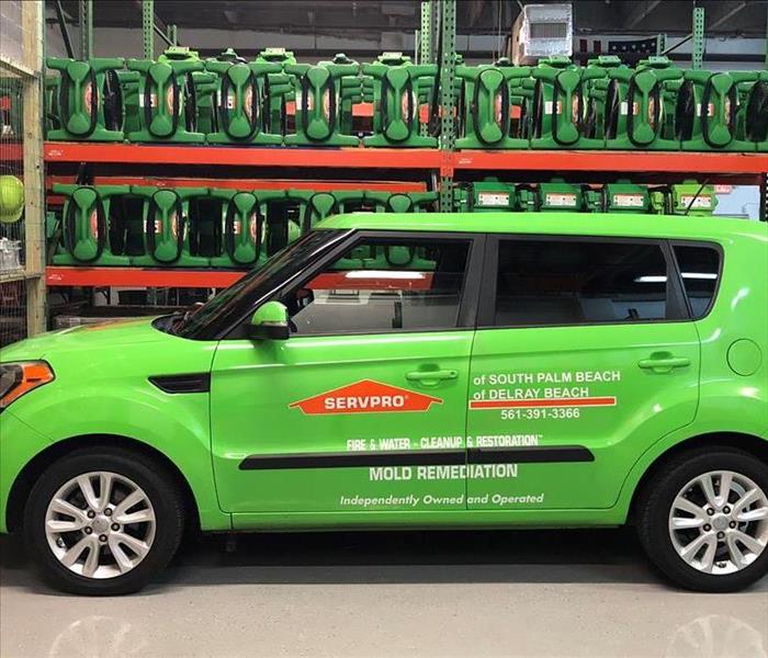 Green SERVPRO car parked in warehouse.