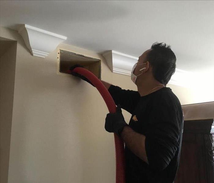 Man cleaning vents.